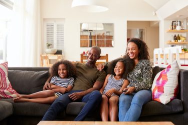 family-sitting-on-sofa-at-home-and-watching-movie-on-tv-together.jpg